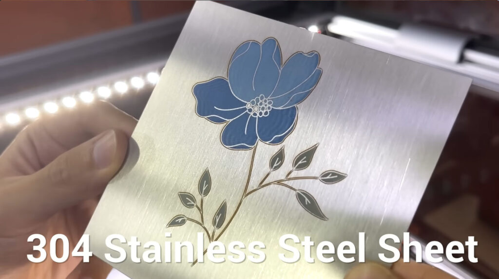 Laser engraving a colorful flower on a steel sheet.