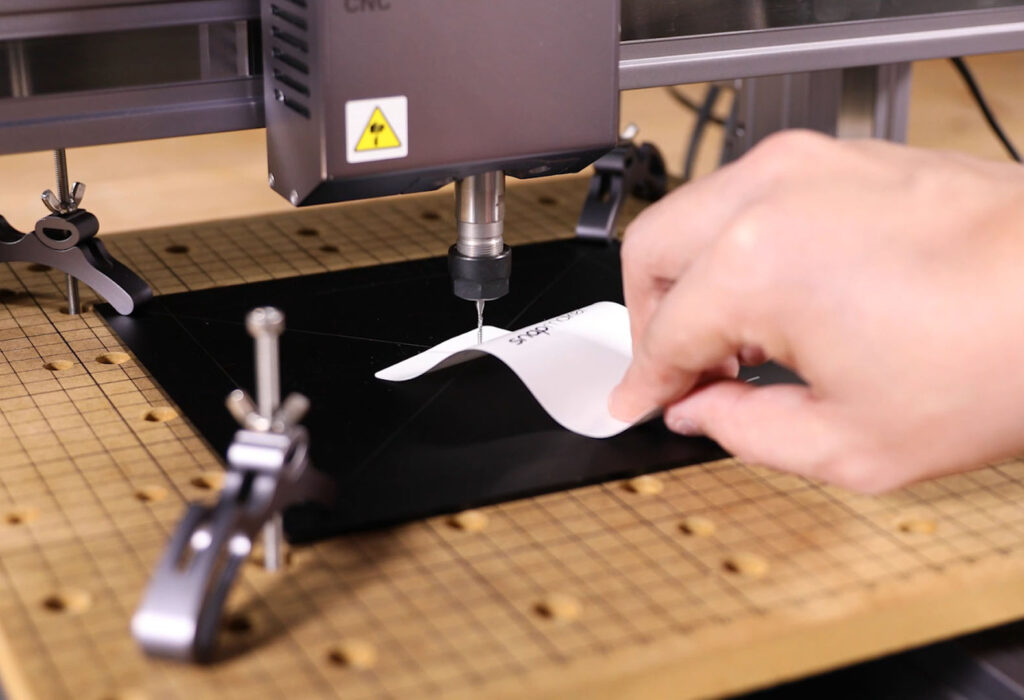 Use a piece of paper to align the CNC drill bit with the platform.