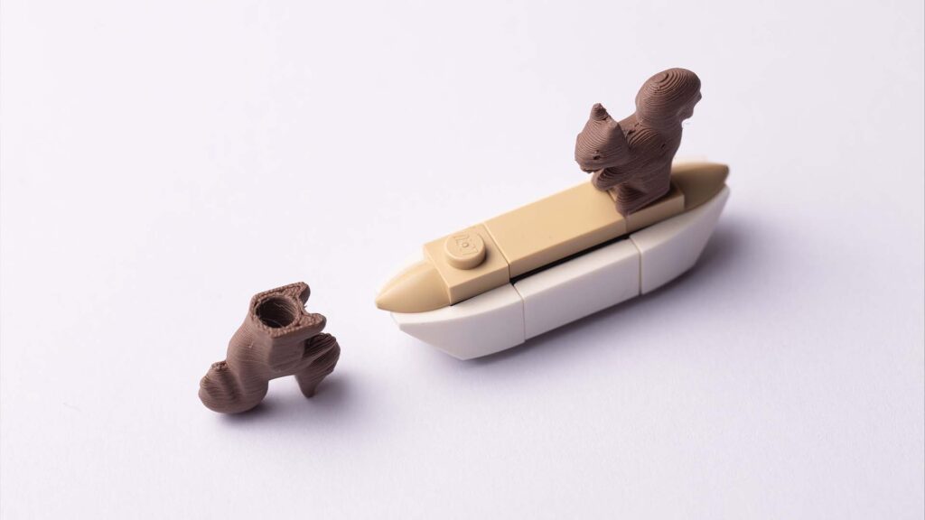 Two small, single-stud squirrel figures within the LEGO ecosystem on the stud.